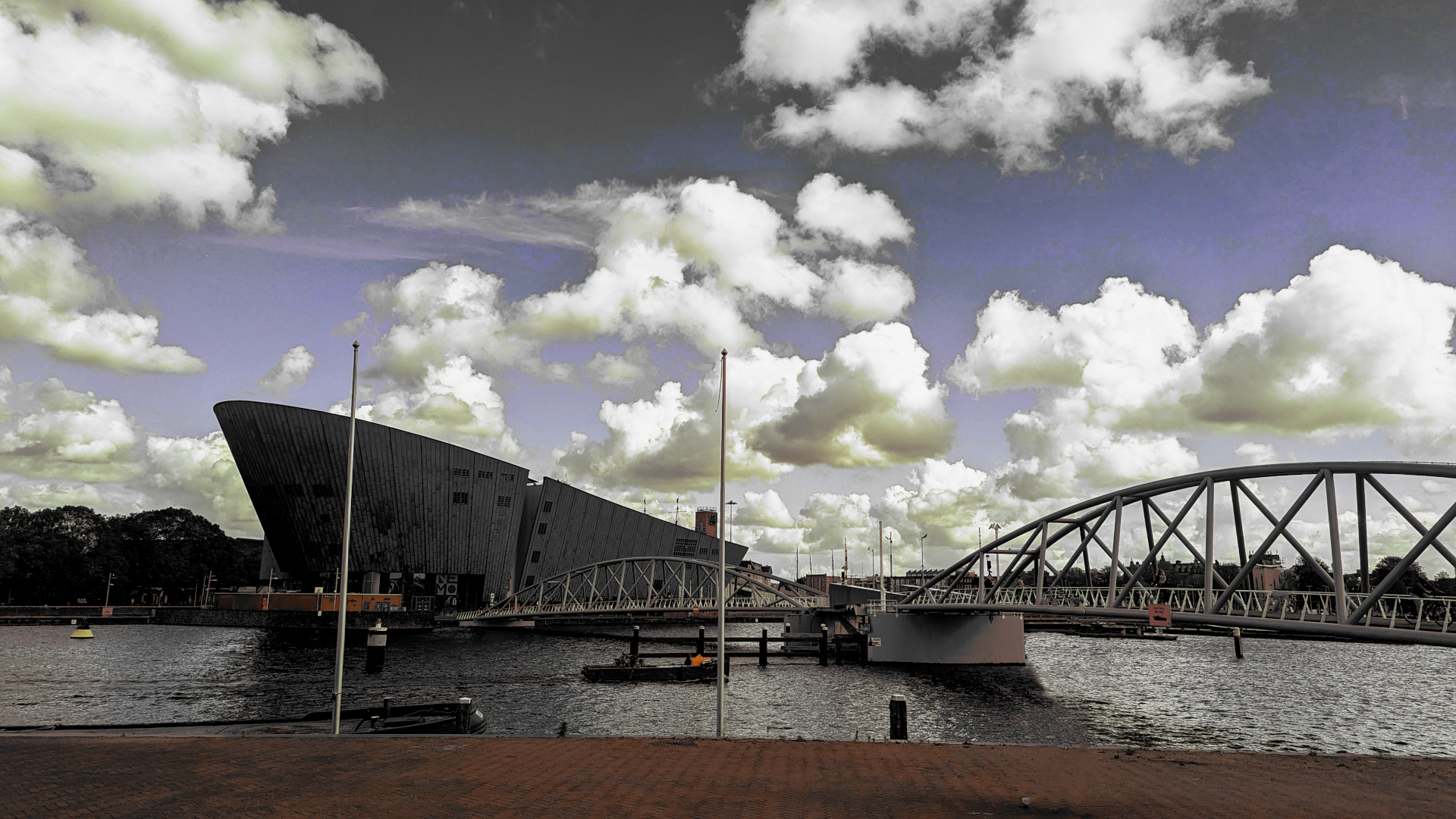 Nemo museum in Amsterdam complete with water and bridge in a darken landscape